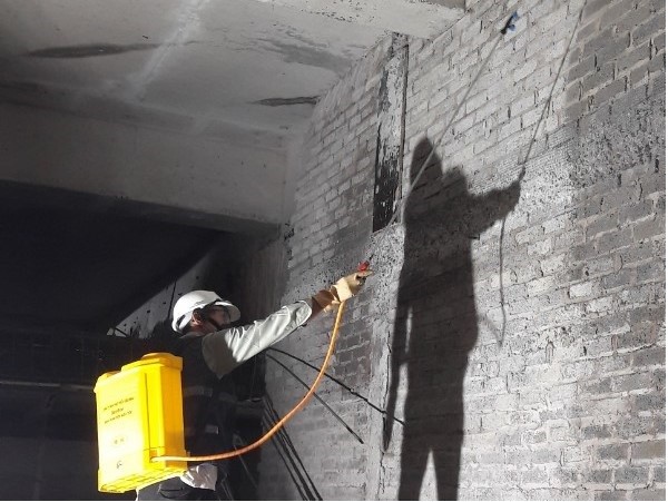 Kỹ thuật viên phun thuốc phòng chống mối cho tường hầm 